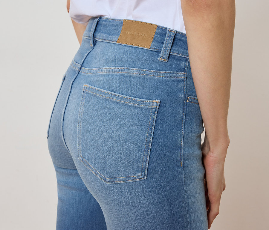 Közeli kép egy világoskék farmert viselő nőről.