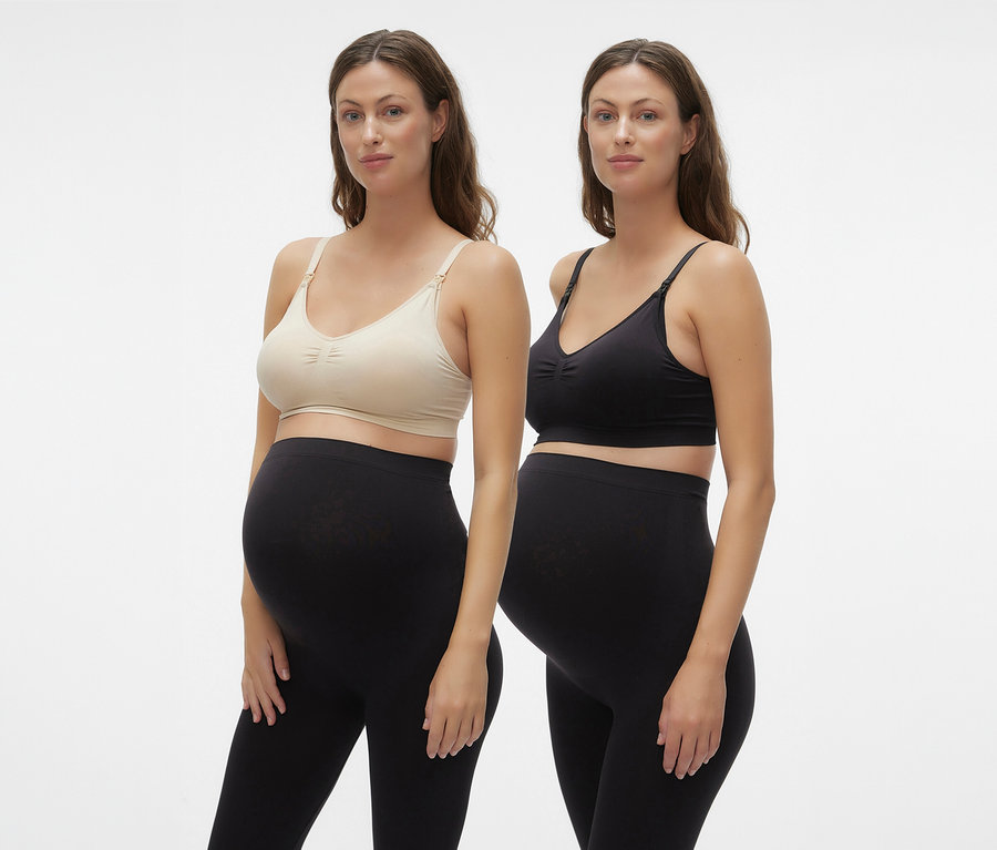 Két terhes nő visel MAMALICIOUS szoptatós melltartót és fekete leggingset fehér háttér előtt.