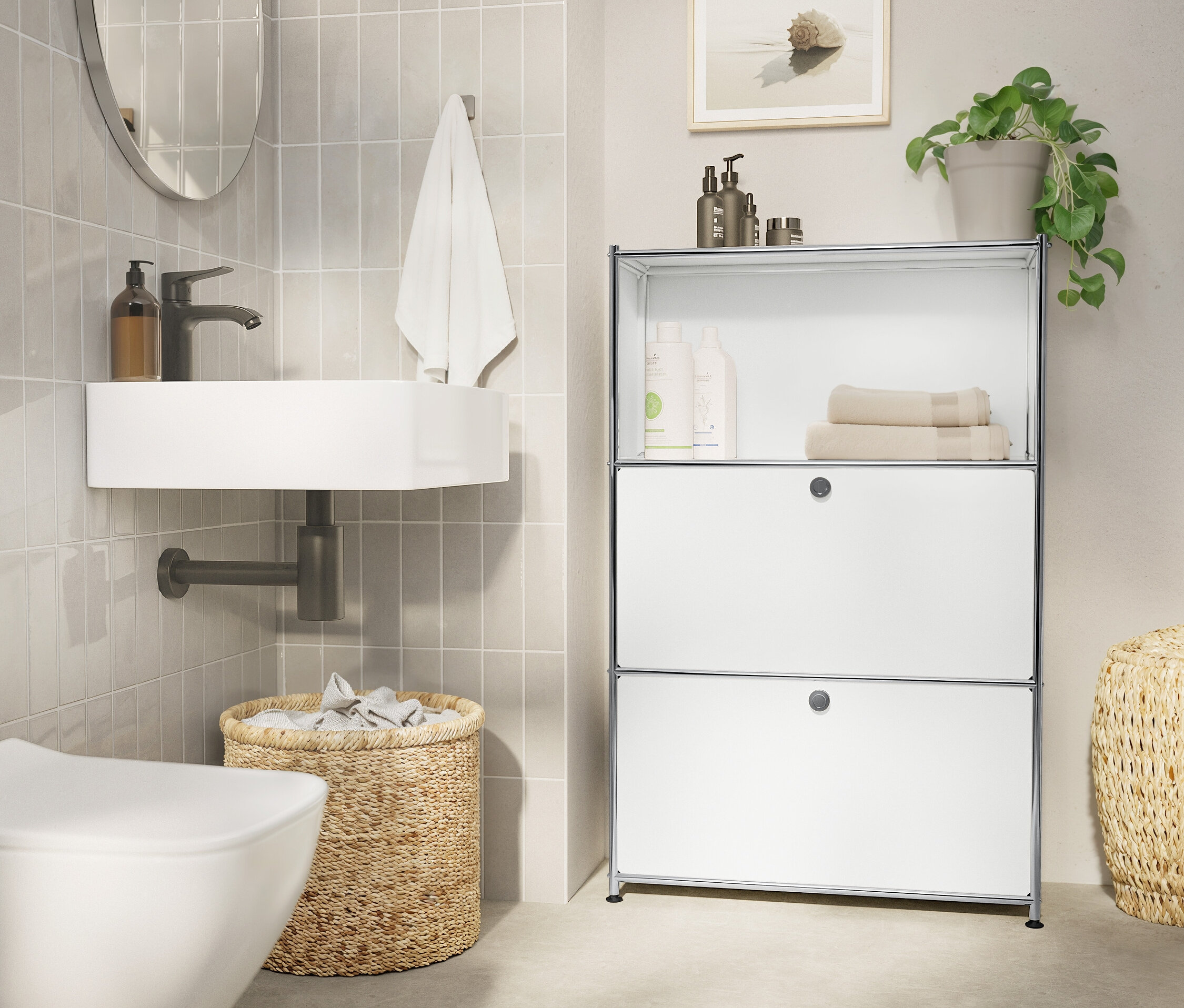 Fürdőszoba fehér mosdókagylóval, ovális tükörrel, törölközővel, fonott kosárral és fehér polccal.