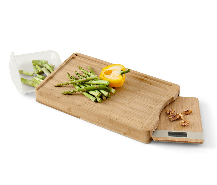 Bambusz vágódeszka digitális mérleggel, sárga paprikával és spárgával.