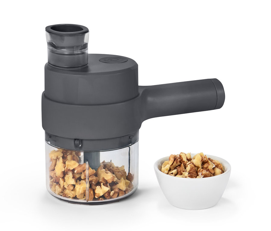 Akkumulátoros multifunkcionális aprító dióval a tartályban és egy tálban.
