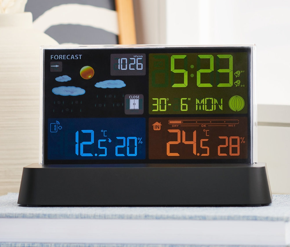 Egy rádióvezérelt időjárásjelző állomás egy könyvön áll.