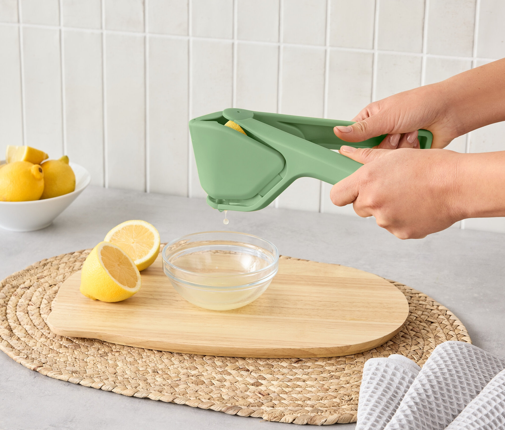 Nő egy helytakarékos citruspréssel citromot présel egy tálba.