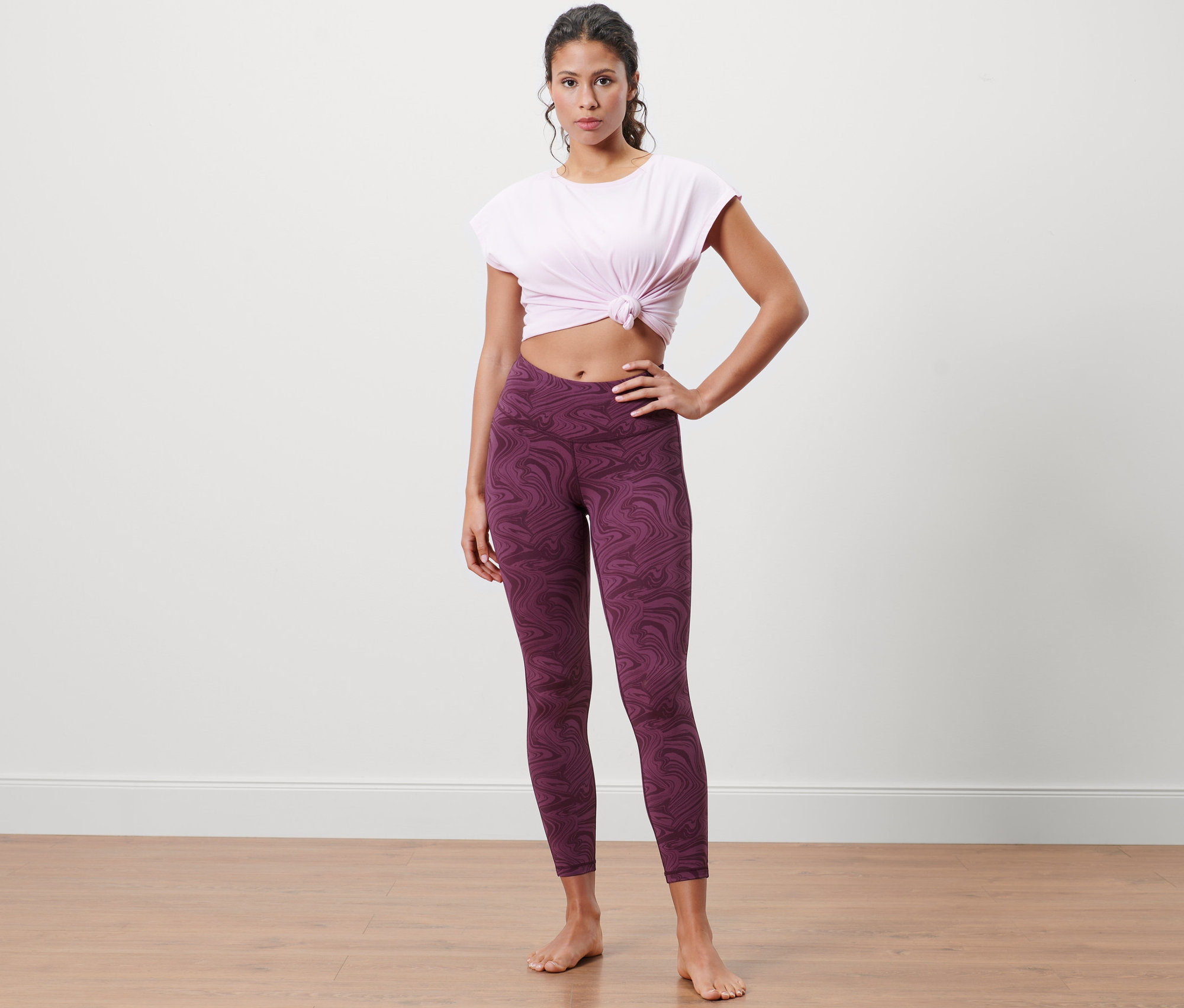 Nő pózol mályva színű, mintás, női 7/8-os sportnadrágban.