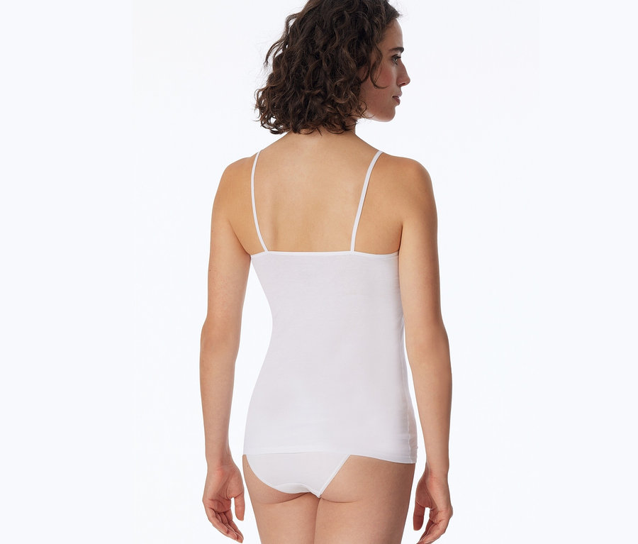 Hátulról látható egy barna, göndör hajú nő, aki fehér SCHIESSER topot és fehér bugyit visel.