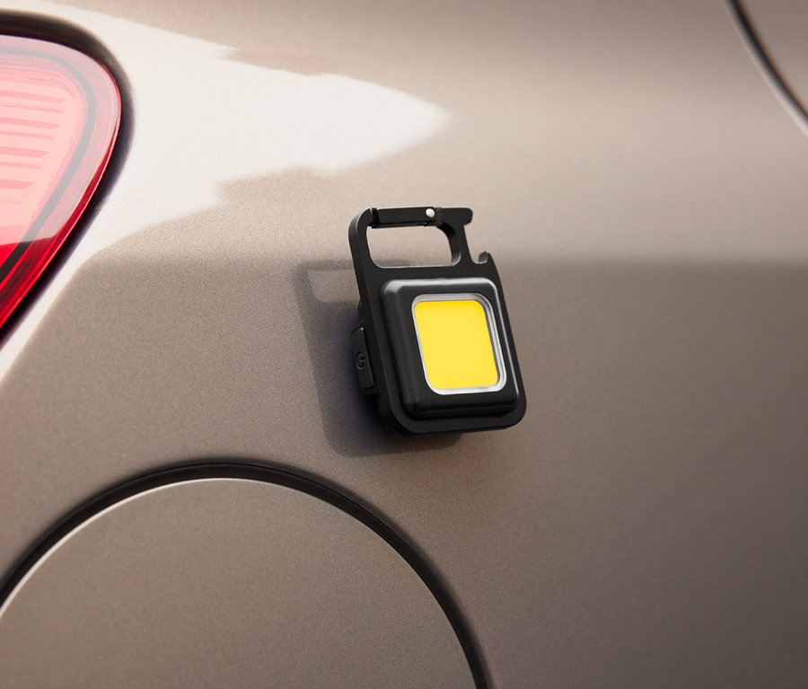 Egy multifunkcionális kempinglámpa van rögzítve egy autóhoz.