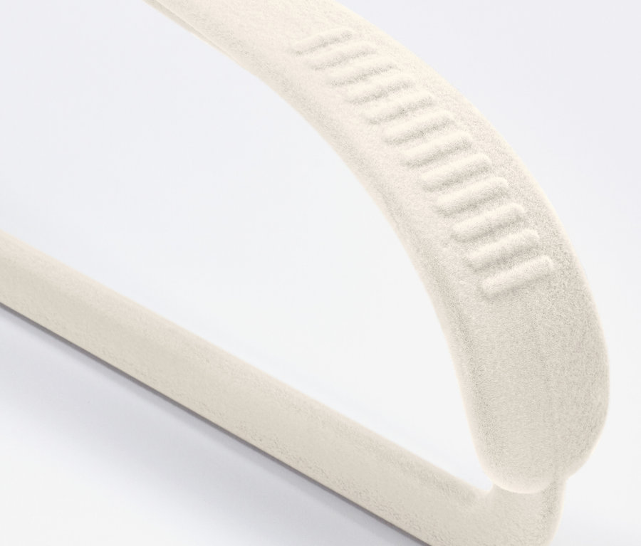 Egy krémszínű, bársony ruhafogas részlete csúszásgátló bevonattal, fehér háttérrel.