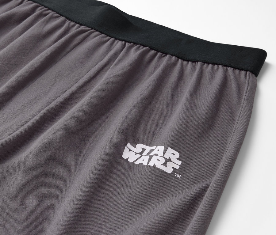Szürke nadrág részlete fekete derékpánttal és Star Wars logóval.