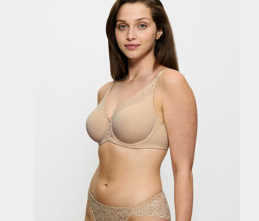 Nő visel Triumph Amourette kicsinyítő testszínű melltartót és hozzáillő alsót.