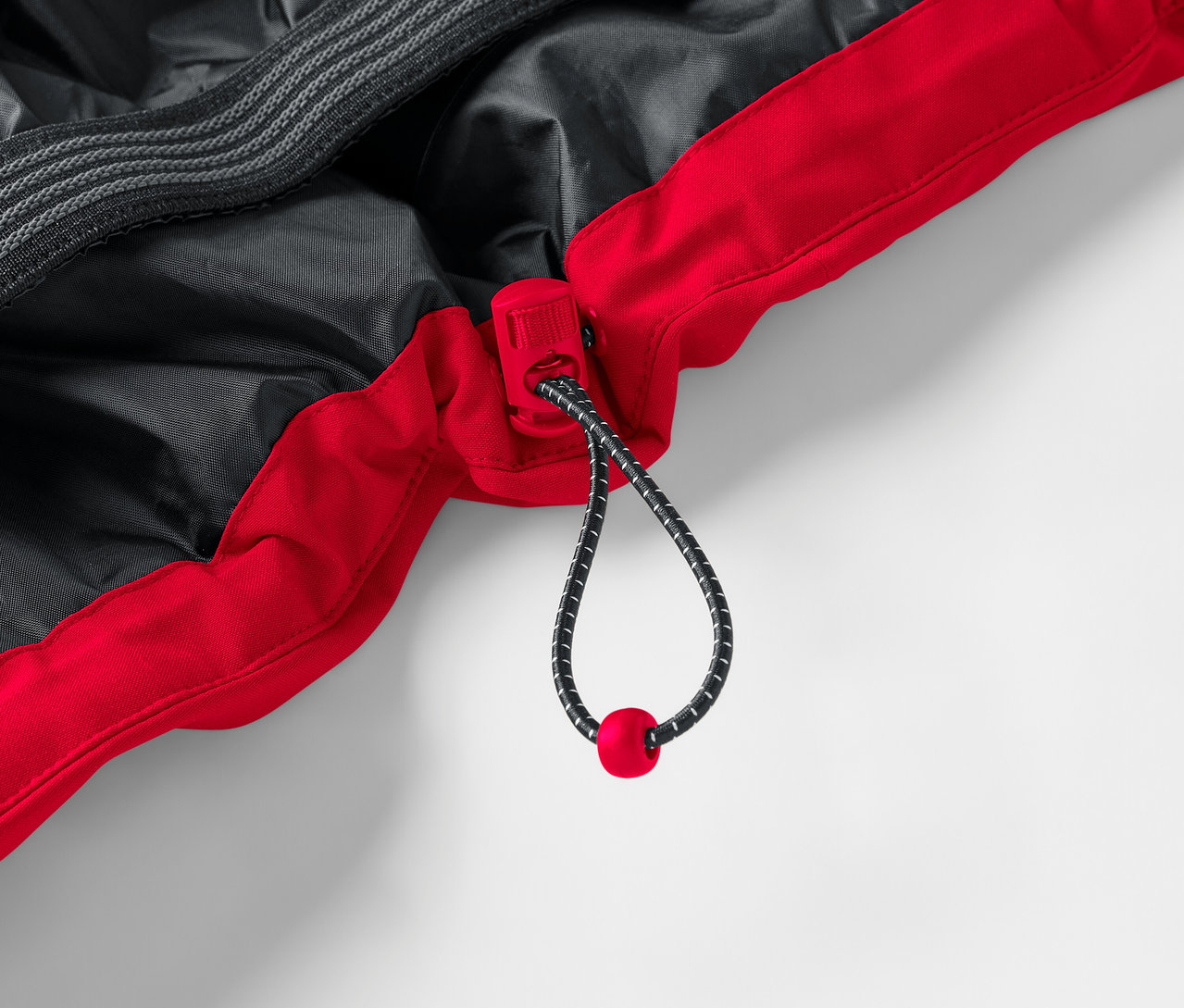 Egy piros-fekete kabát részlete zsinórral.