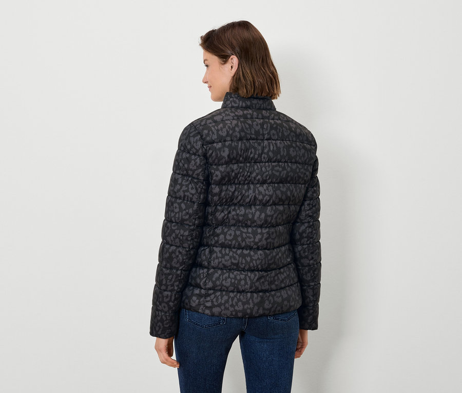 Hátulról látható nő fekete, állatmintás steppelt kabátot és farmert visel.