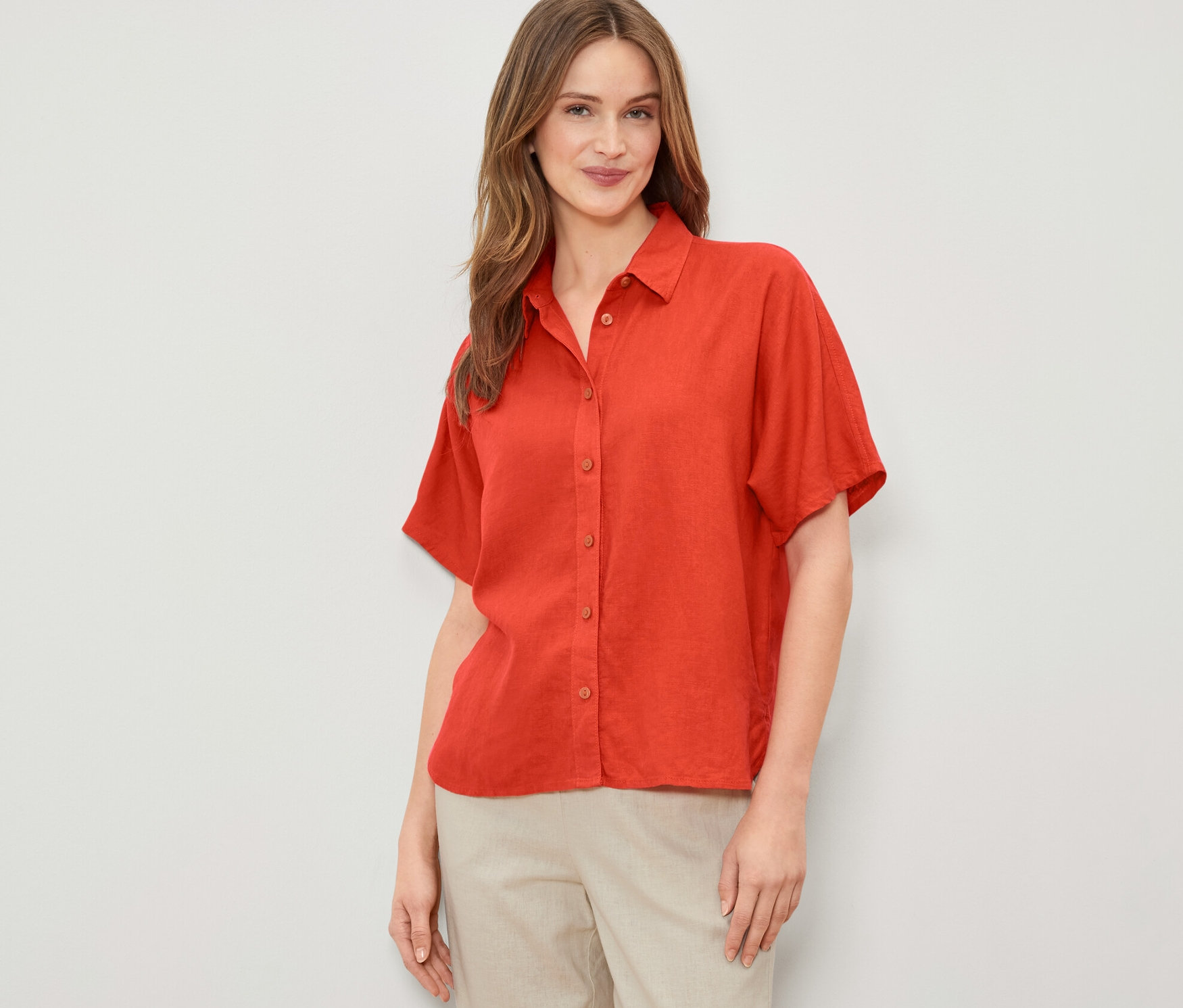 Nő visel narancssárga lenvászon blúzt.