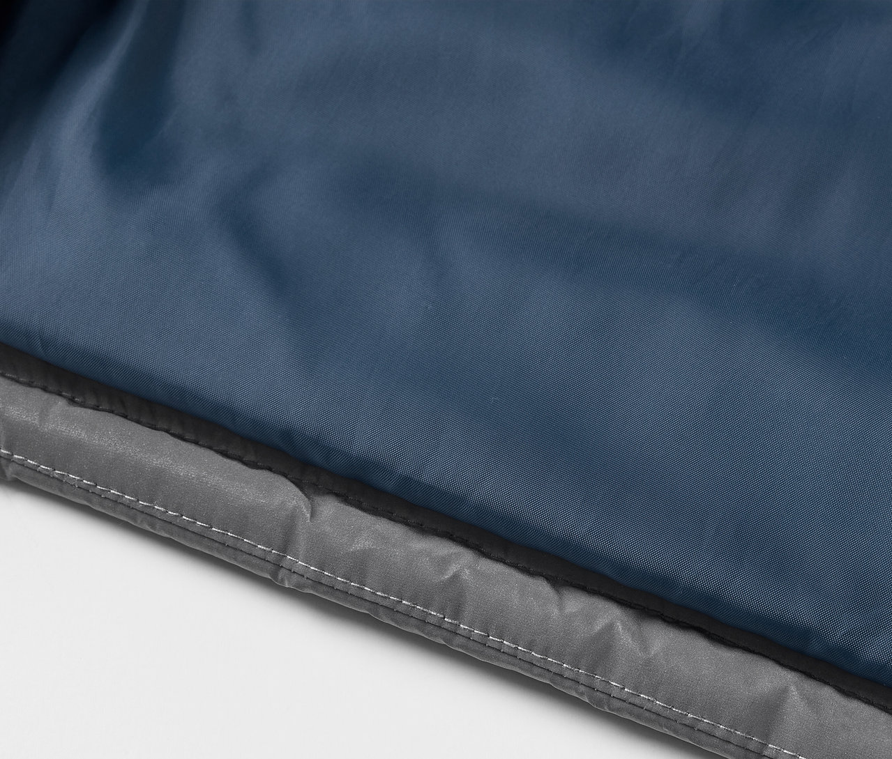 Közelkép egy fényvisszaverő, steppelt gyermekmellényről.