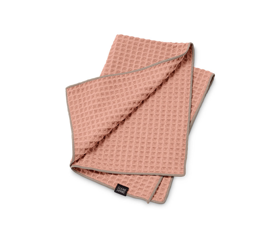 Egy rózsaszín Speciális törlőkendő, nagyméretű szürke szegéllyel összehajtva egy fehér háttéren.