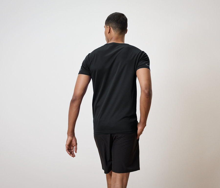 Hátulról látható férfi fekete pólóban és rövidnadrágban.