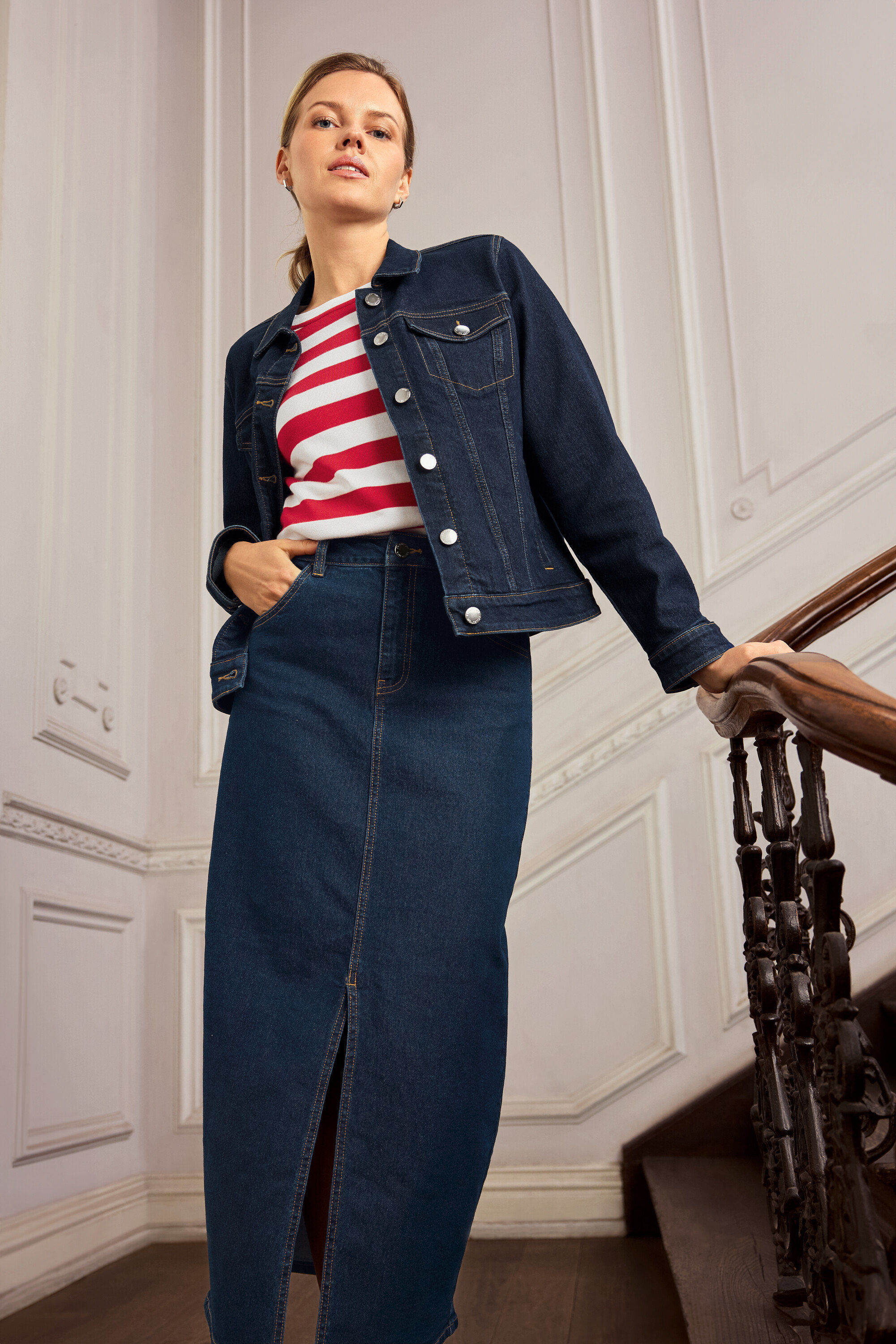 Farmerdzsekis és farmer szoknyás nő pózol egy lépcsőn. 925 Silver Creolen Hexagon fülbevalót visel.