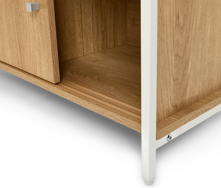 Egy világosbarna fa szekrény részletes nézete fehér lábakkal.