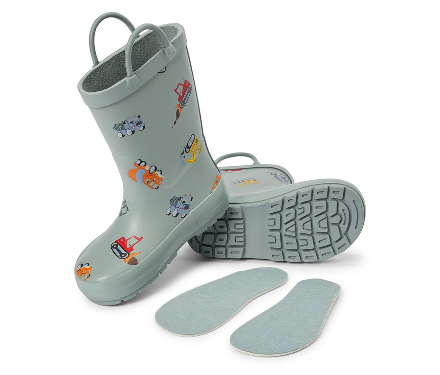Egy pár világoskék gyerek gumicsizma építőmunkás mintákkal és talpbetétekkel fekszik egy fehér háttéren.