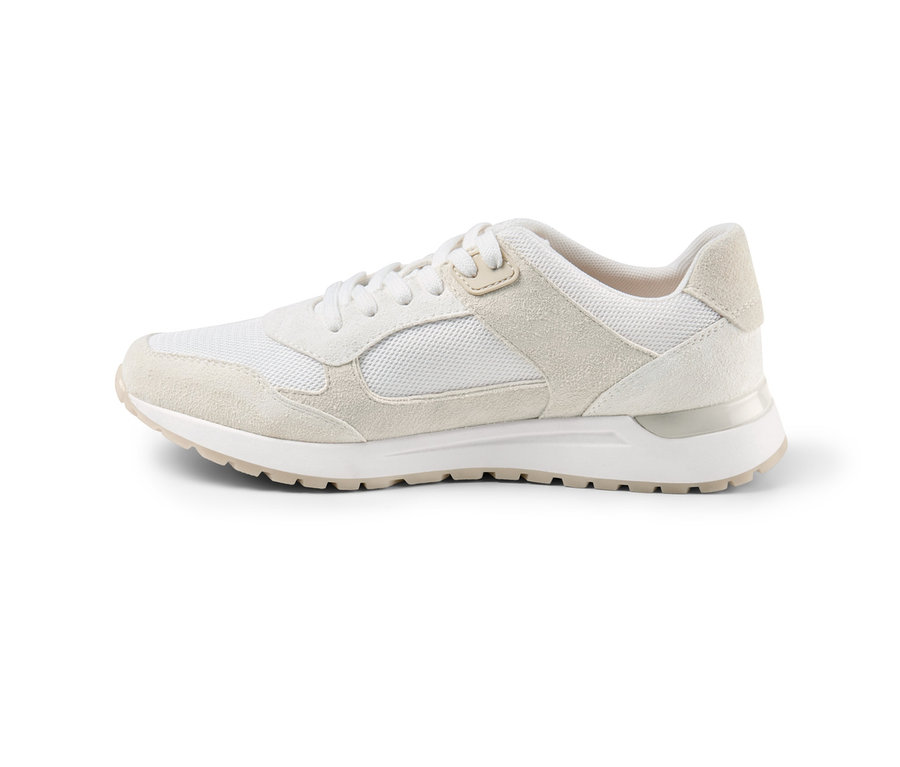 Egy krémszínű női velúrbőr sneaker cipő fehér háttéren.