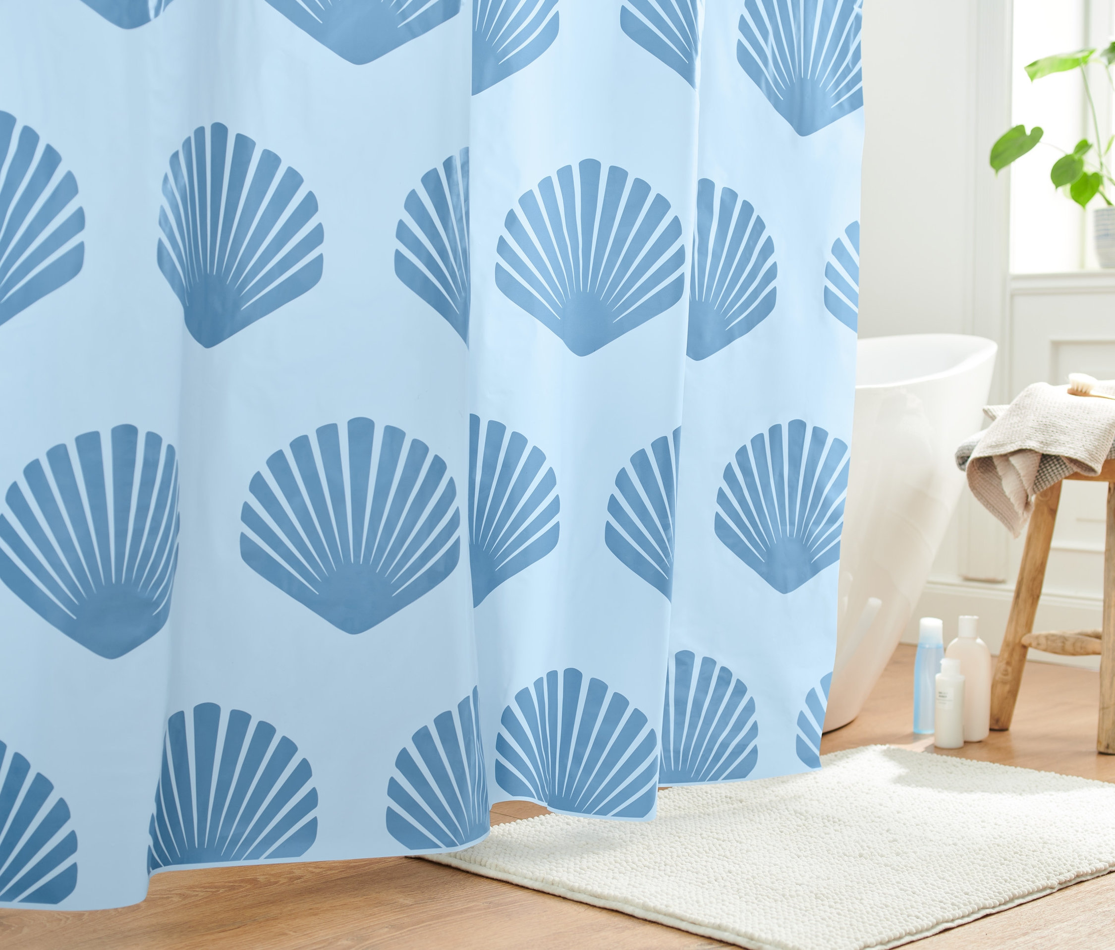Kék kagylómintás zuhanyfüggöny a fürdőszobában.