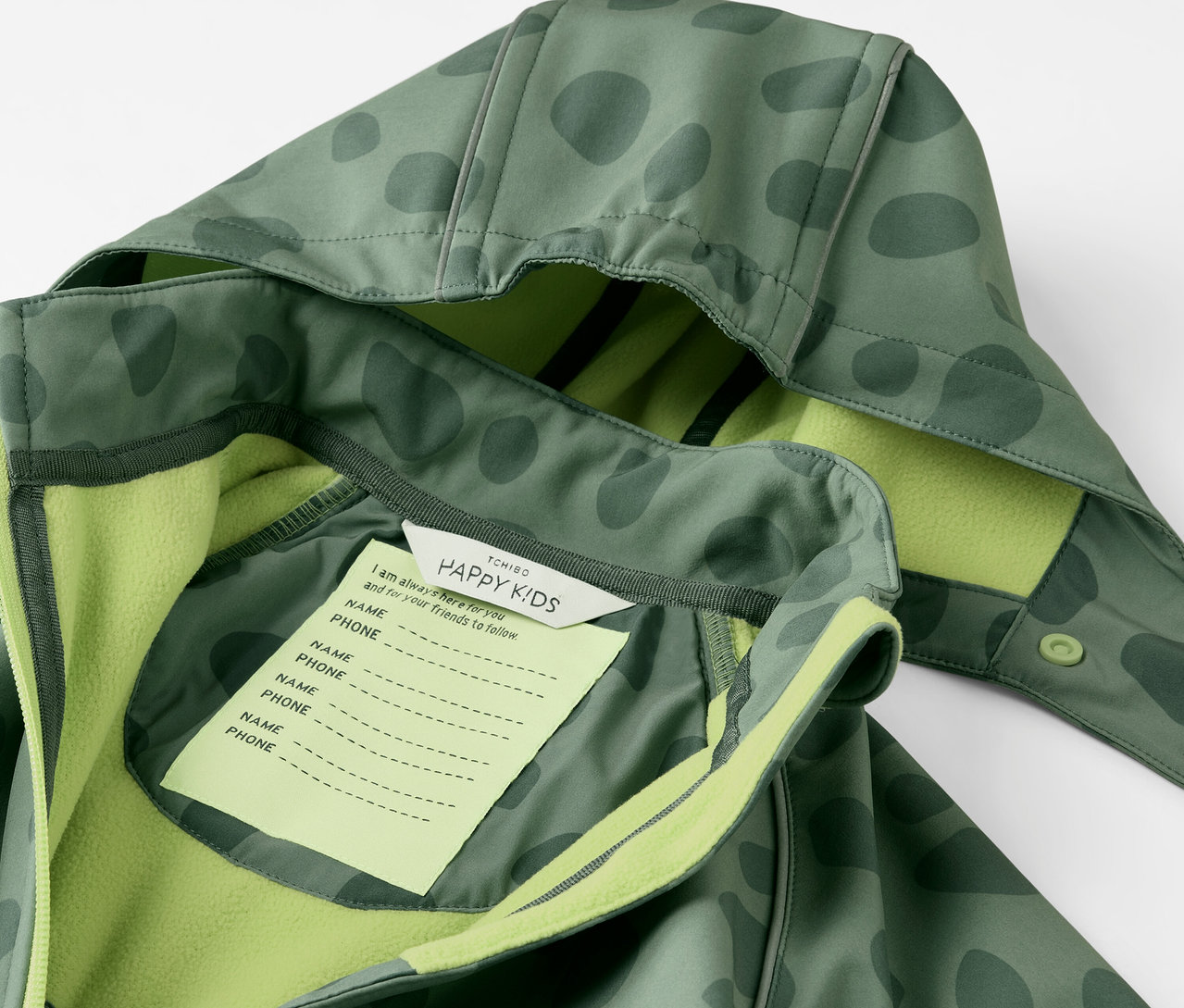 Egy gyermek softshell kezeslábas részlete kapucnival és névtáblával.