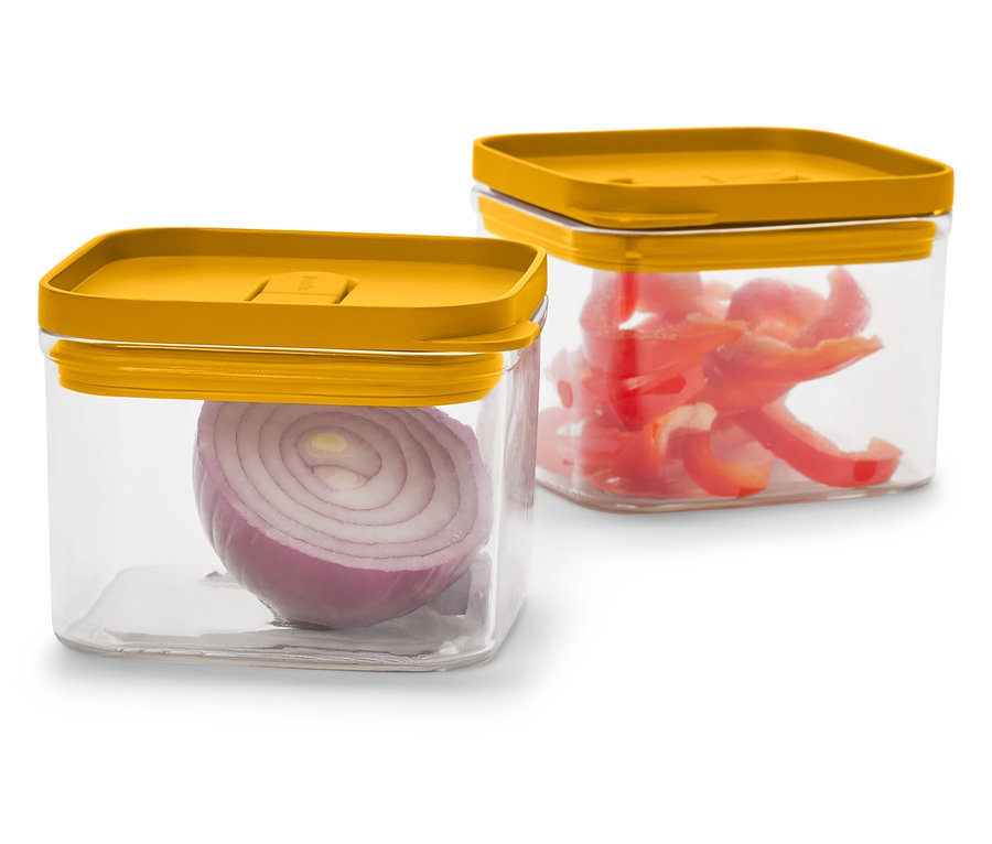 Két átlátszó, négyszögletes tároló mustársárga fedővel. Az egyikben egy fél vöröshagyma, a másikban vágott piros paprika van.
