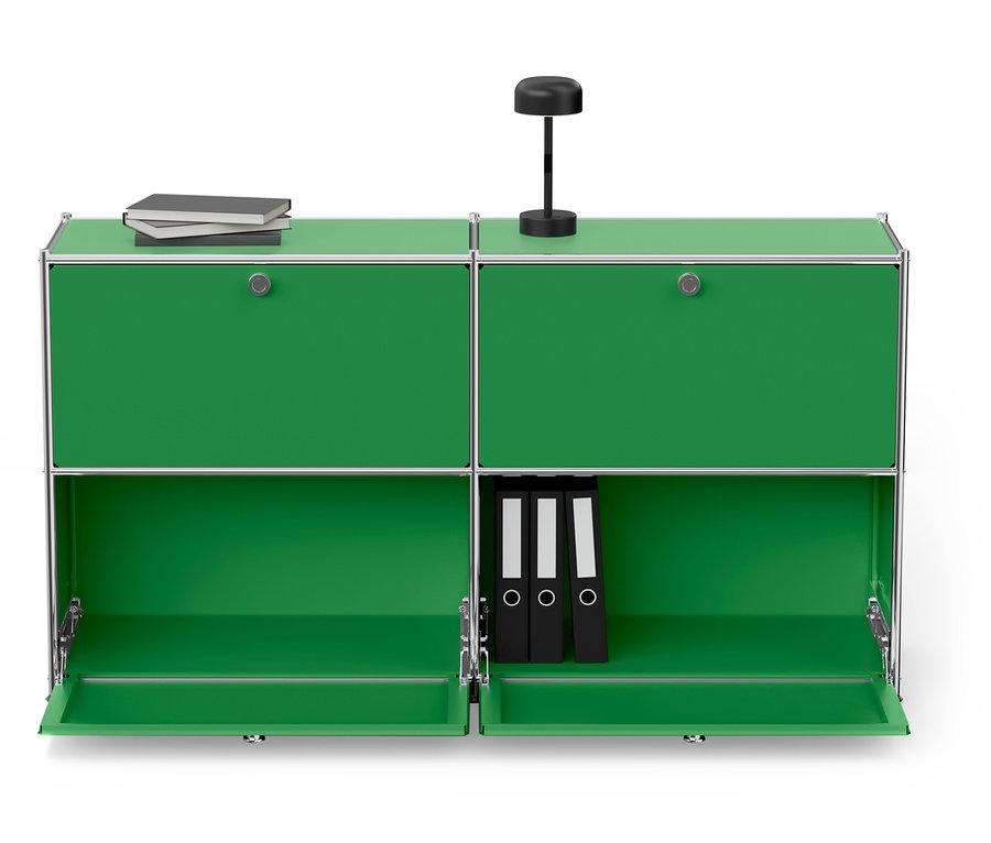 Zöld moduláris szekrény ezüst kerettel, tetején lámpa és könyvek, alul három fekete iratgyűjtő.