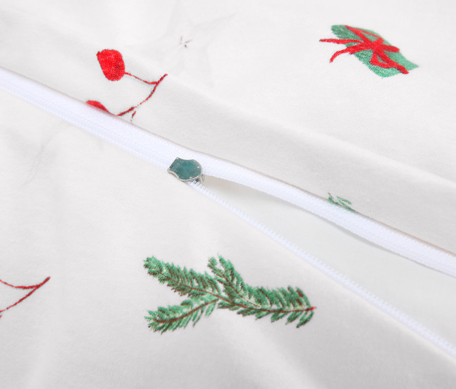 Egy fehér ágynemű cipzárral és karácsonyi motívumokkal részlete.