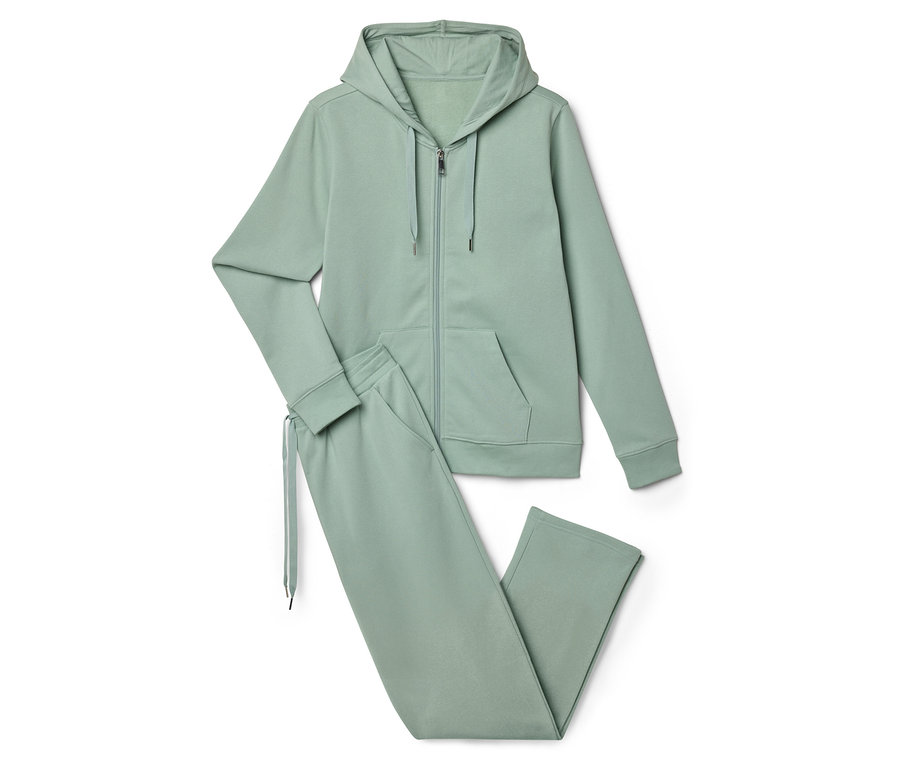 Egy világoszöld tréningruha, amely egy cipzáras kapucnis pulóverből és egy jogging nadrágból áll, fekszik egy fehér háttéren.