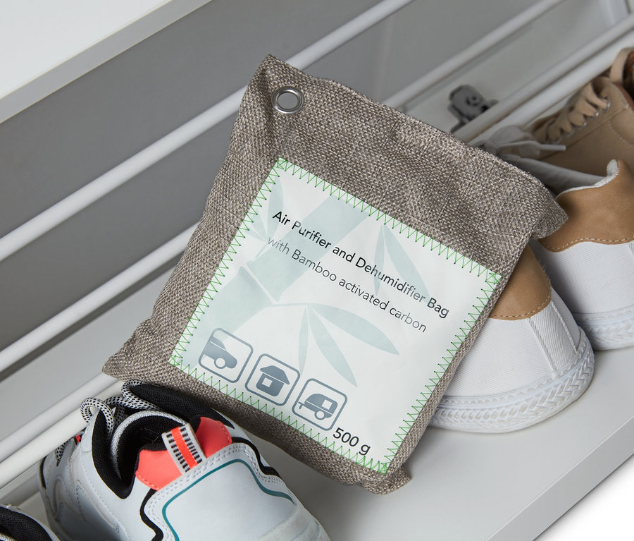 Egy légtisztító és páramentesítő tasak fekszik a cipőkön egy cipőtartóban.