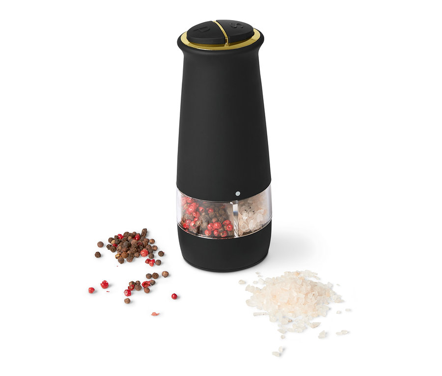 Egy fekete elektromos só- és borsőrlő 2 az 1-ben, átlátszó fűszertartállyal és szétszórt fűszerekkel.