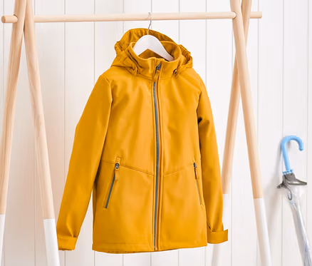 Egy sárga softshell dzseki lóg egy fogason.