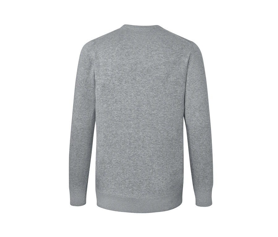 Egy szürke, kerek nyakkivágású kötött pulóver részlete.