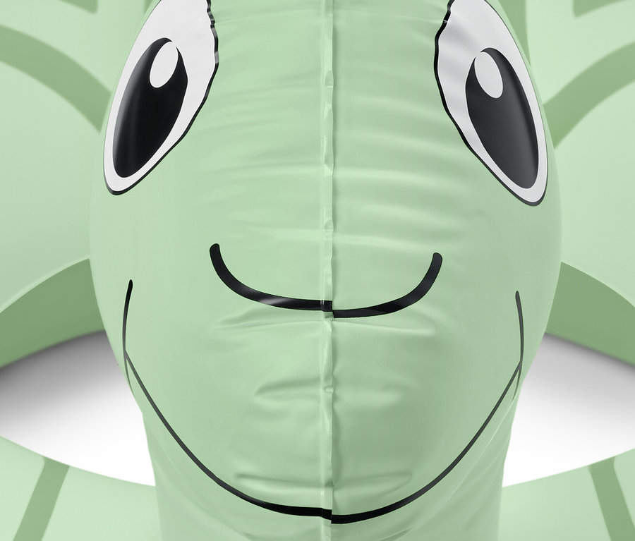 Egy zöld »Teknős« úszógumi részlete szemekkel és mosollyal.