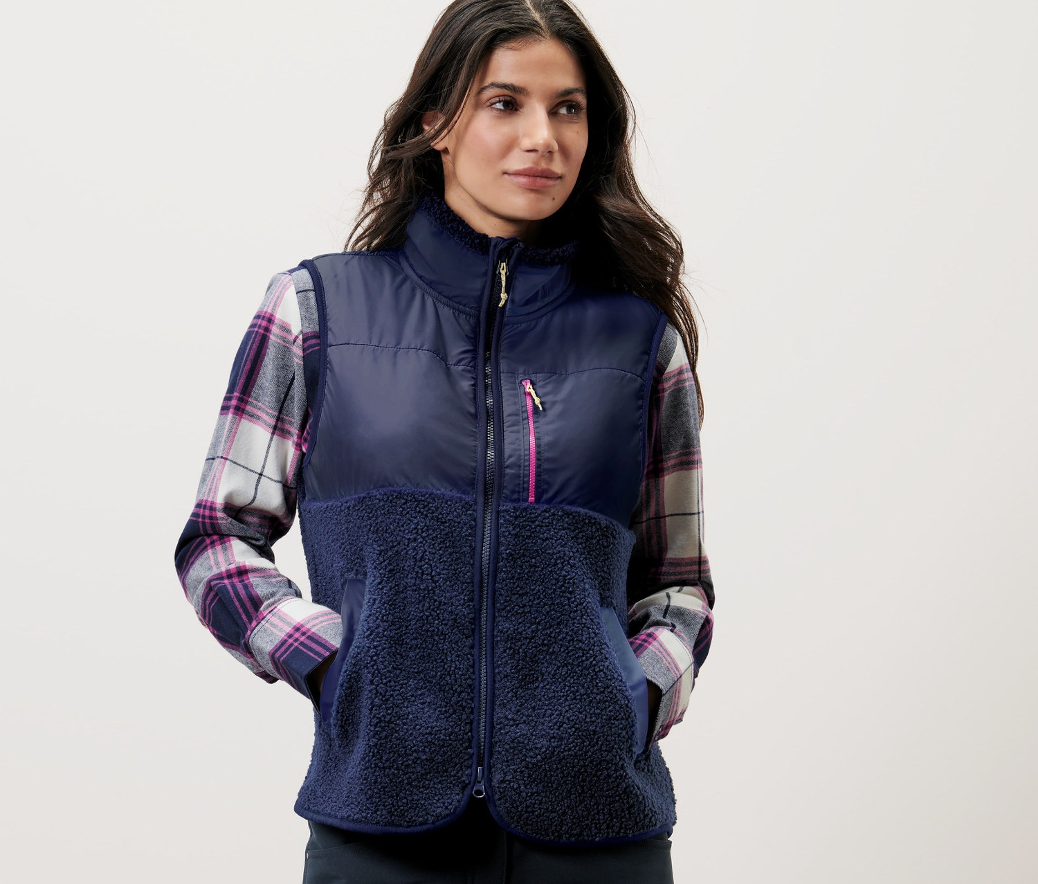 Nő visel egy sötétkék hibrid plüssmellényt.