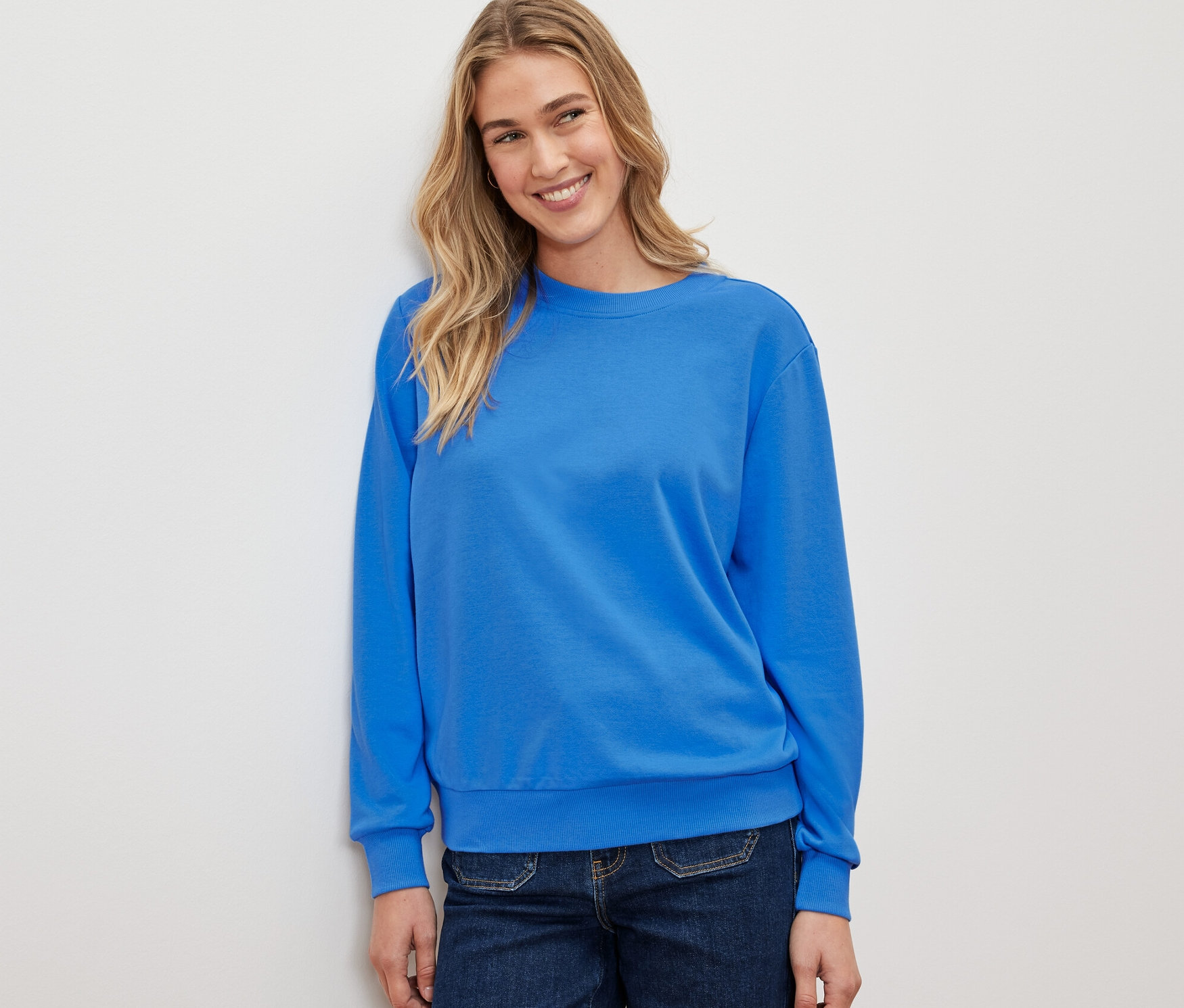 Nő visel kék szabadidőfelsőt.