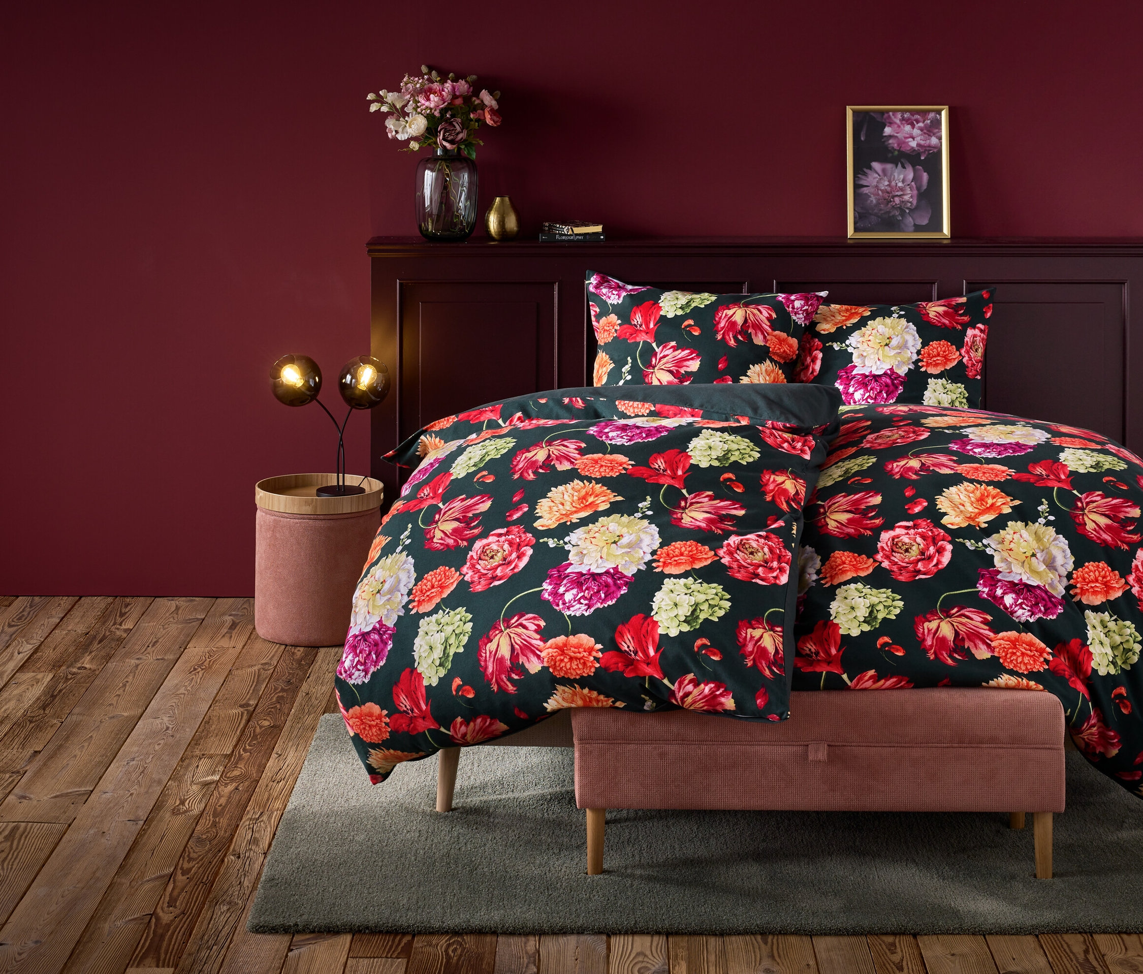 Virágos ágynemű egy ágyon, bordó falú szobában.