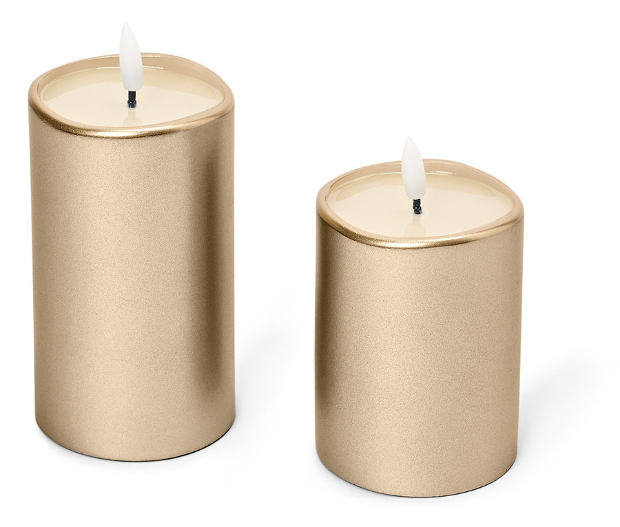 Két arany gyertya áll fehér háttér előtt.
