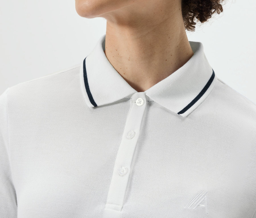 Egy személy felsőteste fehér funkcionális pólóingben.