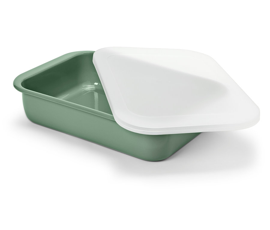 Egy zöld edény fehér fedővel fekszik egy fehér háttéren.