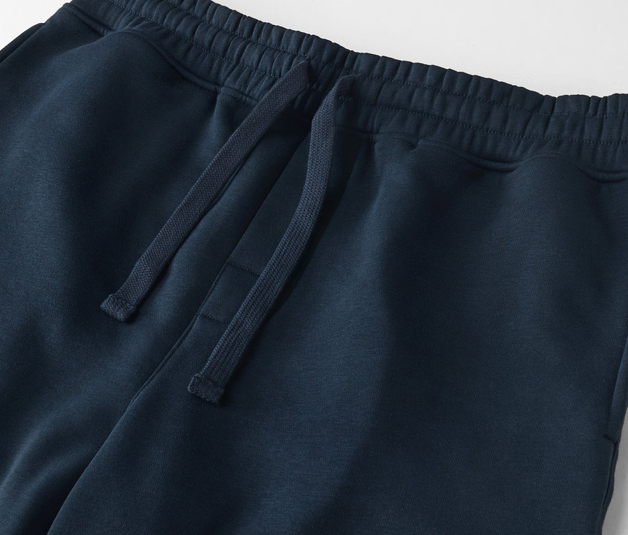 Egy sötétkék színű, húzózsinóros jogging alsó közeli képe.