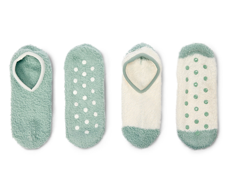 Négy pár bolyhos zokni zöld és fehér színben fekszik egy fehér háttér előtt.