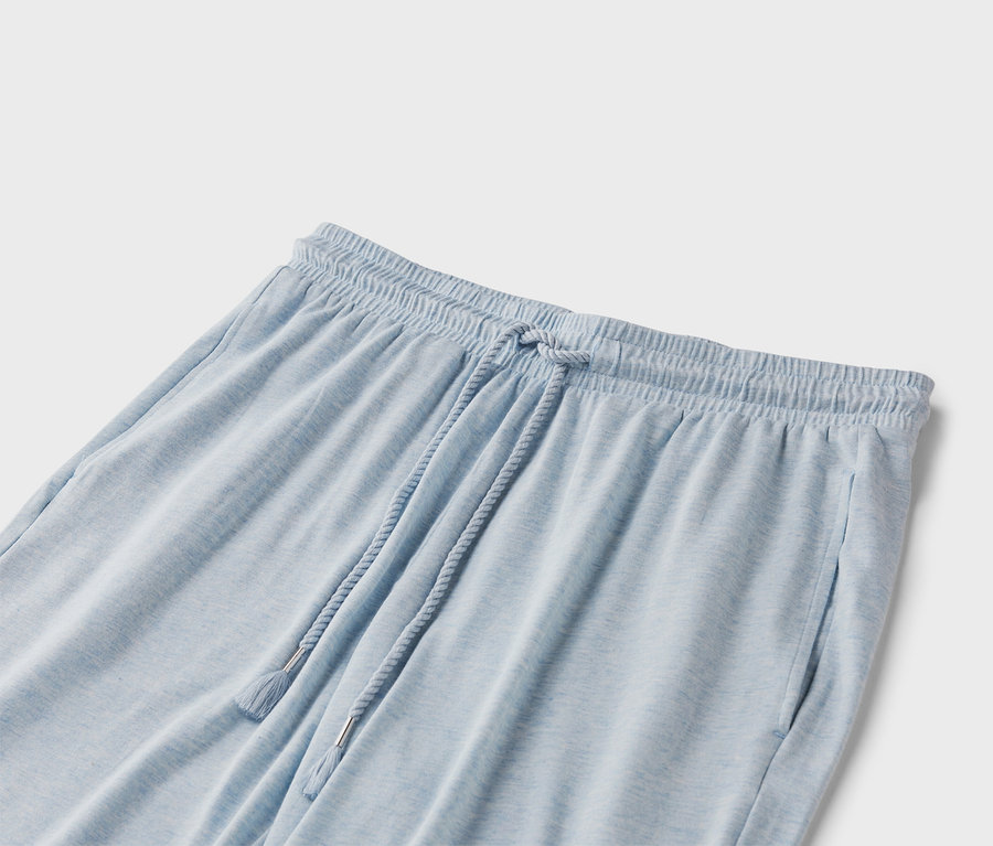 Egy világoskék színű, húzózsinóros jogging nadrág közeli képe.