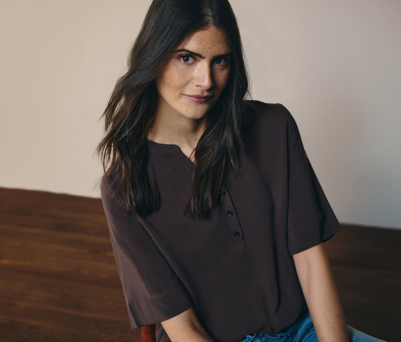 Nő visel barna CECIL tunikablúzt és farmert.