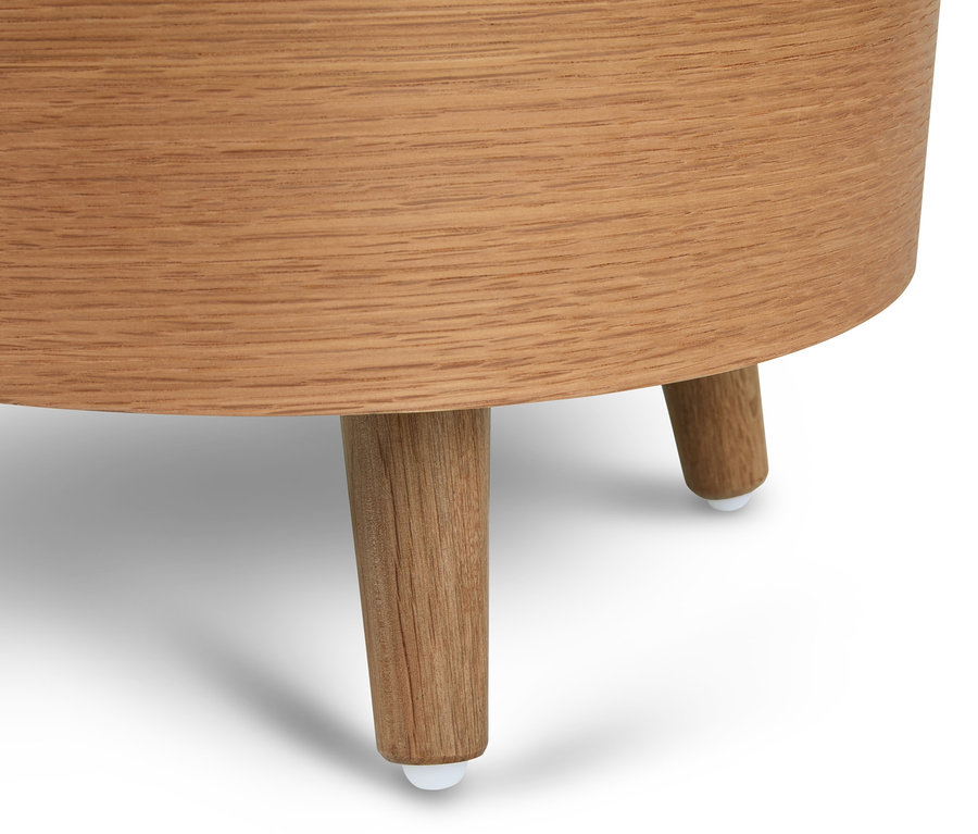 Egy kerek, tárolóval rendelkező lerakóasztal részlete, látható fa lábakkal.