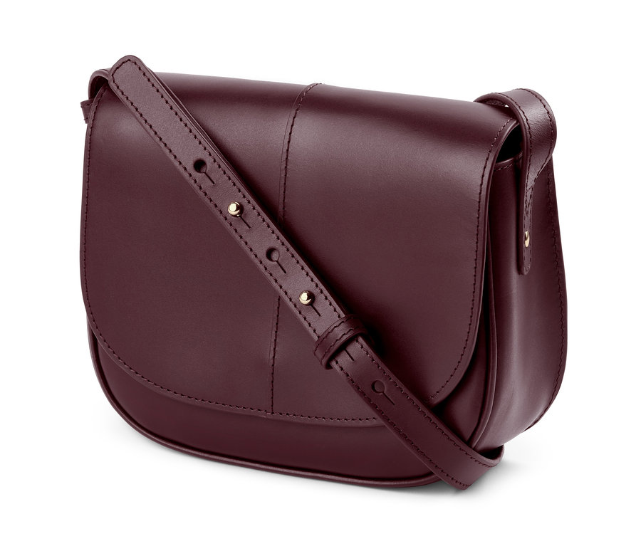 Egy bordó színű »Saddle Bag« bőr kézitáska részlete, állítható pánttal.
