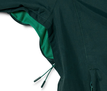 Egy sötétzöld férfi funkcionális túradzseki részlete.