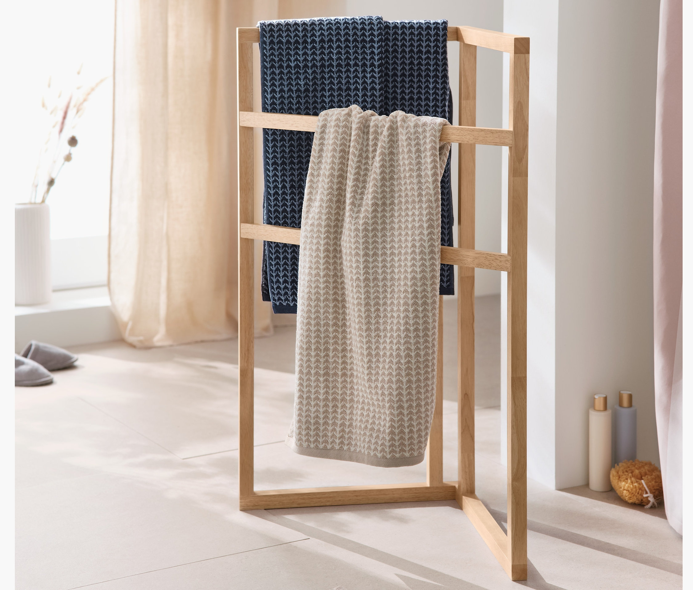 Sarok törölközőtartó állványon kék és bézs színű 2 prémium törölköző szettben.