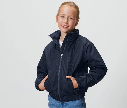 Lány pózol sötétkék gyerek blouson dzsekiben.