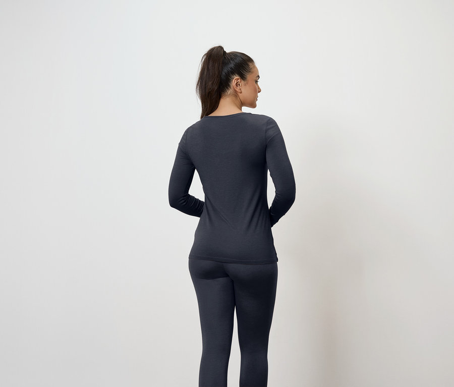 Hátulról látható nő sötétkék hosszú ujjú felsőben és leggingsben.